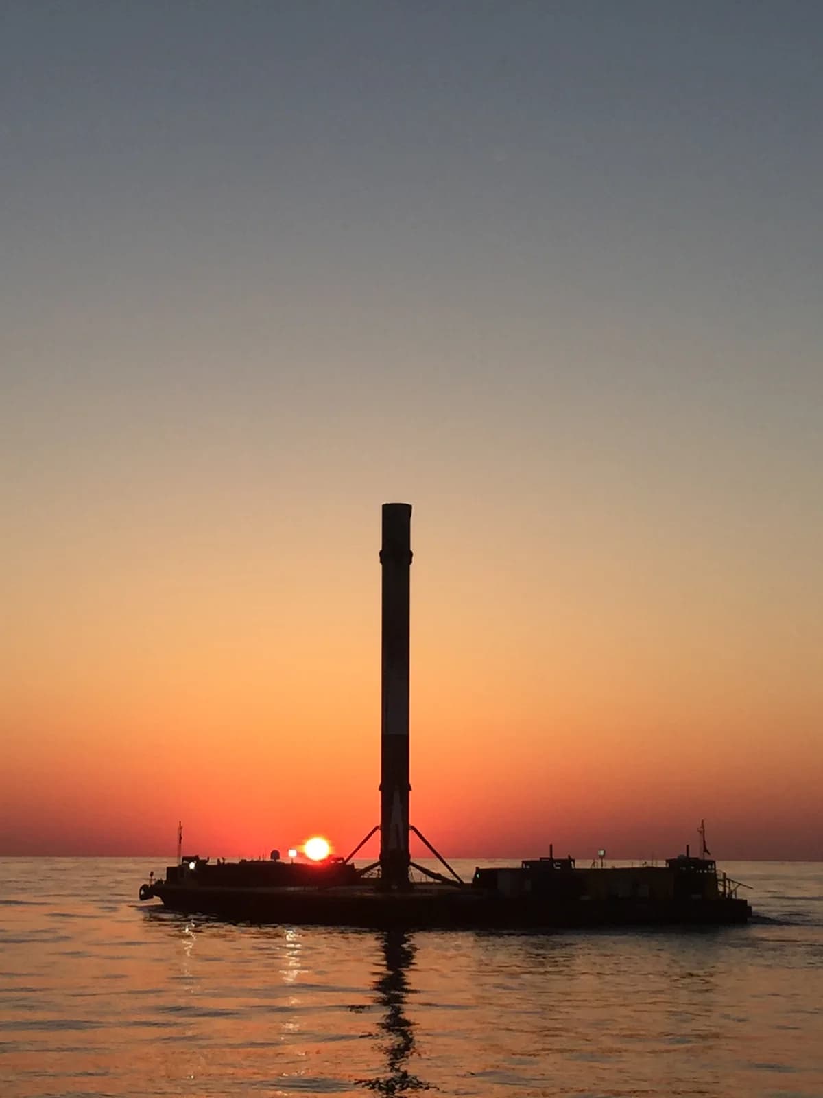 A recovered Falcon 9 booster returning to port aboard a droneship